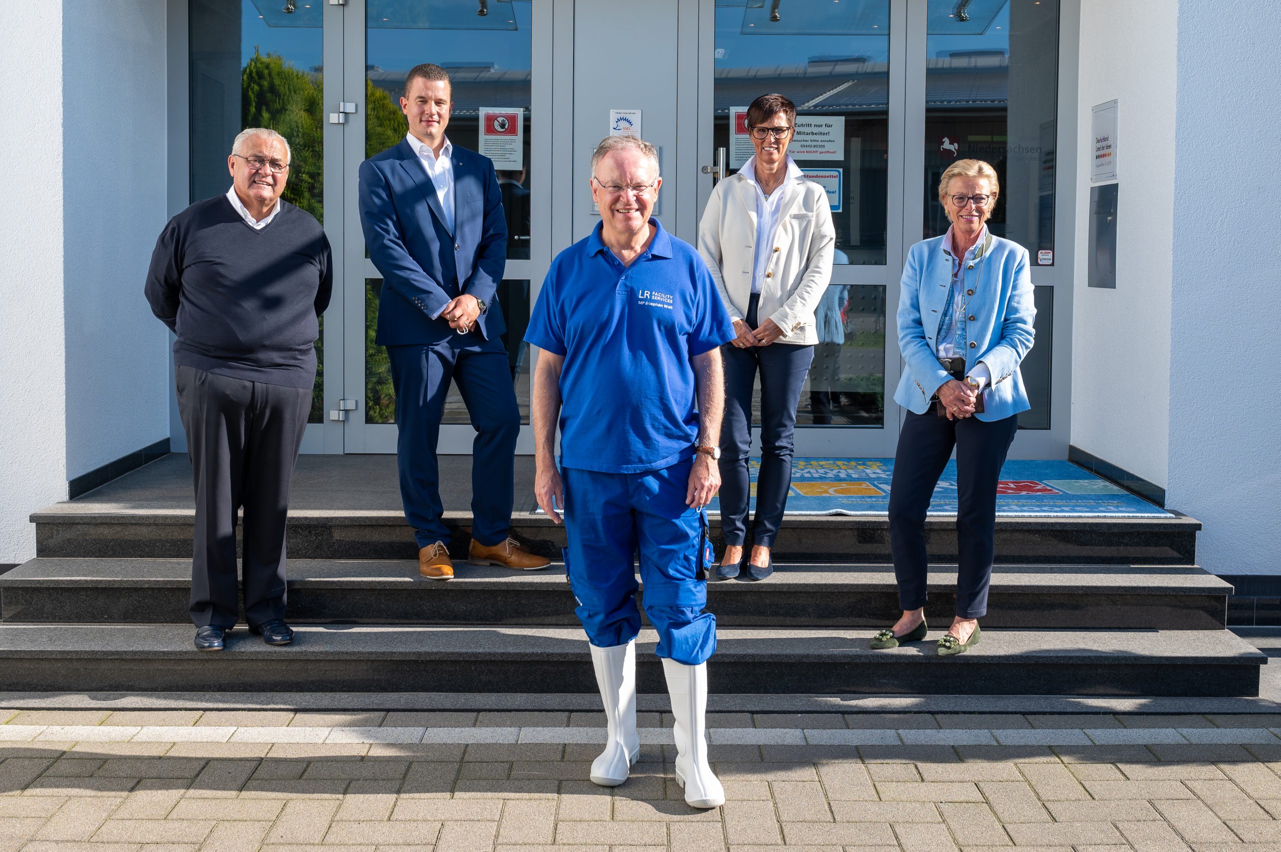 Gruppenfoto: Vier Personen, darunter die Inhaberfamilie mit Mitarbeiterin und dem niedersächsischen Ministerpräsidenten a.D. Stephan Weil vor dem Firmengebäude am Haupteingang auf der Treppe. Gruppenfoto: Vier Personen, darunter die Inhaberfamilie mit Mitarbeiterin und dem niedersächsischen Ministerpräsidenten a.D. Stephan Weil vor dem Firmengebäude am Haupteingang auf der Treppe.